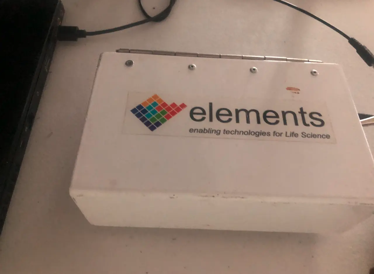A white hinged metal enclosure with the Elements label and cables trailing from it